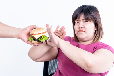 Portrait of woman holding apple against white background