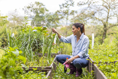 Side view of young woman sitting on land