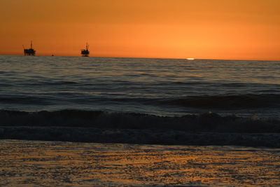 Scenic view of sea against orange sky