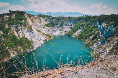 Scenic view of lake by mountains against sky