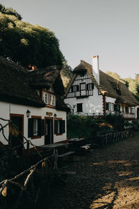 Houses by buildings in town against clear sky