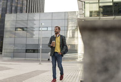 Man walking with coffee cup in city