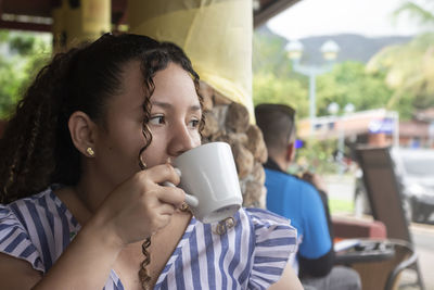 Latin woman drinking coffee