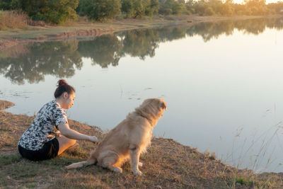 Reflection of man with dog on lake