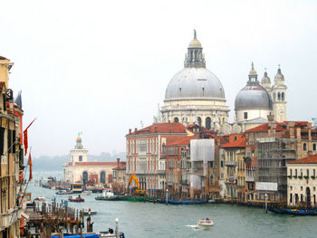 Santa maria della salute by venetian lagoon seen from accademia bridge against sky