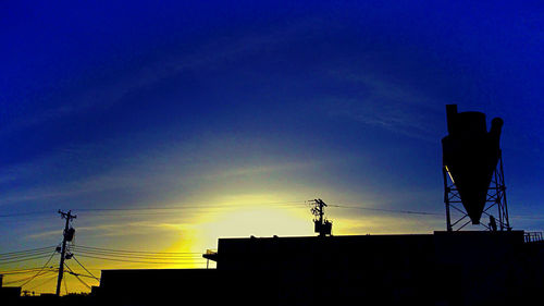 Low angle view of silhouette buildings against sky at sunset