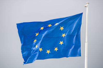 Low angle view of flag against blue sky