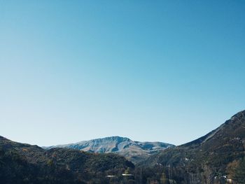 Scenic view of mountains against clear blue sky