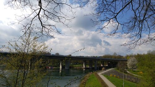 Bridge over river against cloudy sky