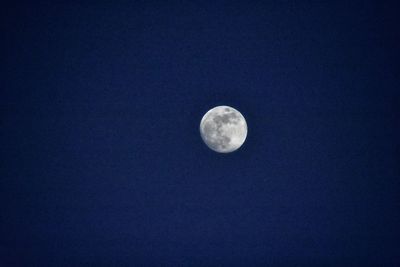 Low angle view of moon against clear blue sky