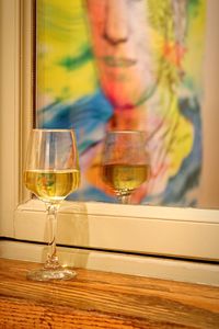 Close-up of wineglass by picture frame on table