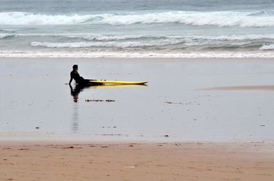 Man surfing on beach against sky