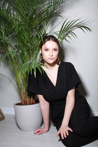 Low angle view of young woman standing against wall