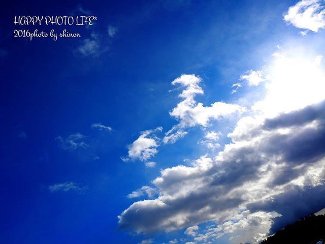 blue, sky, low angle view, cloud - sky, text, communication, western script, nature, cloud, tranquility, beauty in nature, scenics, no people, outdoors, day, sunlight, tranquil scene, cloudy, white color, idyllic