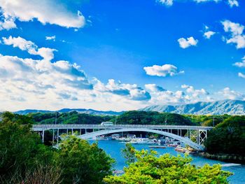 Arch bridge over river against sky
