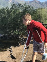 Side view teen boy  on crutches