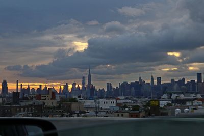 Buildings in city against sky during sunset