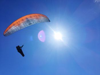 Low angle view of person paragliding against clear blue sky