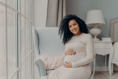 Young woman smiling while sitting at home