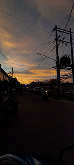 Silhouette electricity pylon against sky during sunset