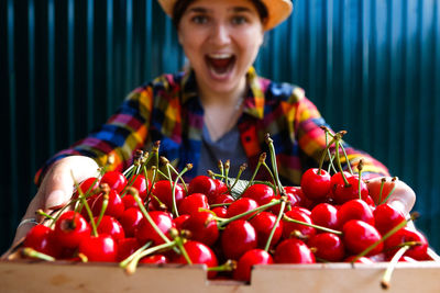 Young woman with red berries in container
