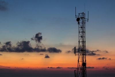 Low angle view of silhouette communications tower against sky during sunset