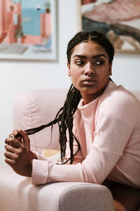 Bored young woman sitting on sofa