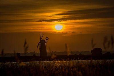 Silhouette statue against sky at sunset