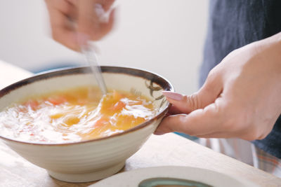 Midsection of person preparing food in bowl