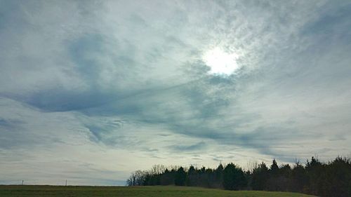 Scenic view of grassy field against cloudy sky