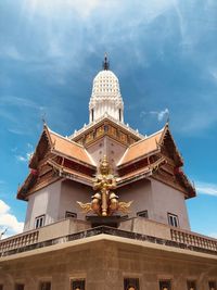 Low angle view of statue by temple against sky