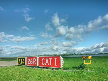 Scenic view of grassy field against cloudy sky