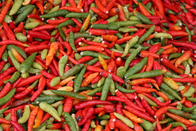 Full frame shot of green and red chili peppers