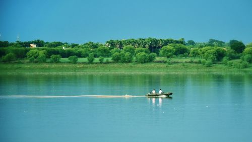 Scenic view of lake against clear blue sky