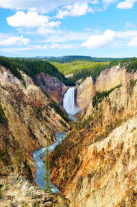 Scenic view of river by mountains against sky