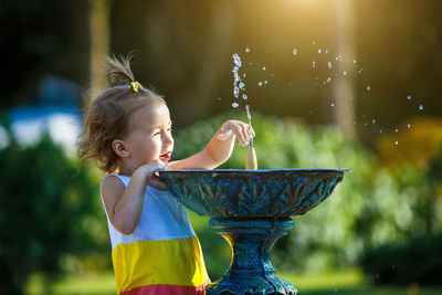 Side view of girl playing with water