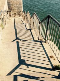 High angle view of stairs by sea on sunny day