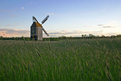 Traditional windmill on field against sky