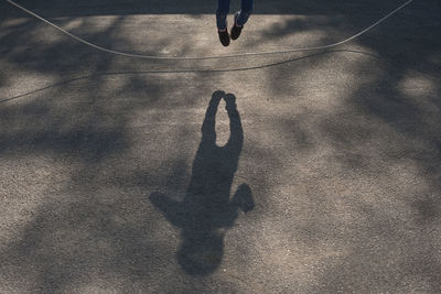 Low section of person with shadow on street