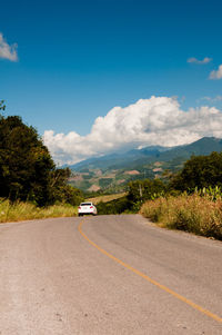 Road by mountain against blue sky