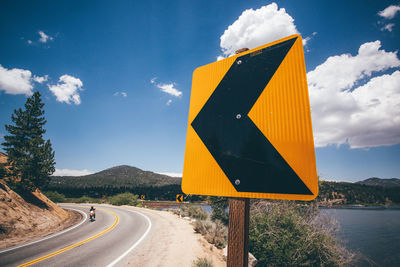 Road sign against sky