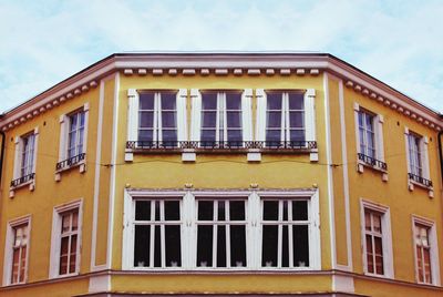 Low angle view of yellow building against sky