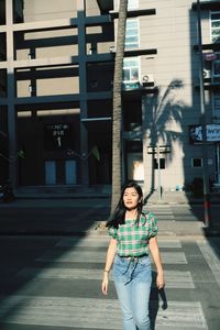 Young woman standing on road in city