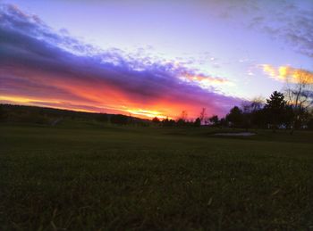 Scenic view of field against sky at sunset