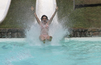 Girl going down and enjoying water slide in water park