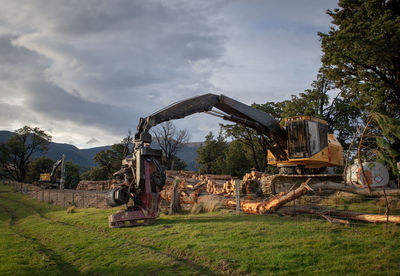 Old machinery on field against sky