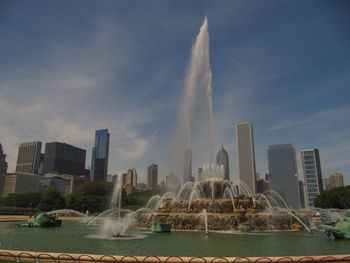 Fountain in city against sky