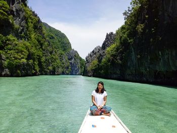 Young woman sitting on boat over sea