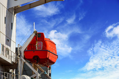 Low angle view of red ship against sky