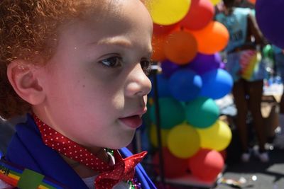 Close-up of boy looking against colorful balloons